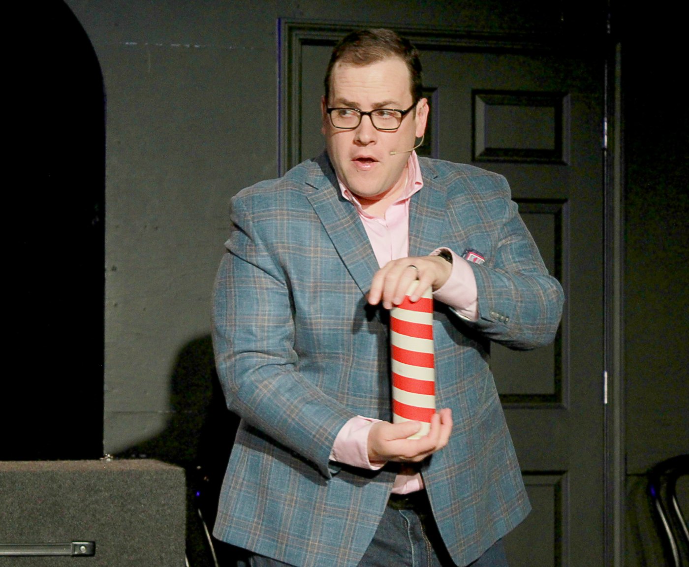 Scott Green working a striped tube prop on stage at iO Theater