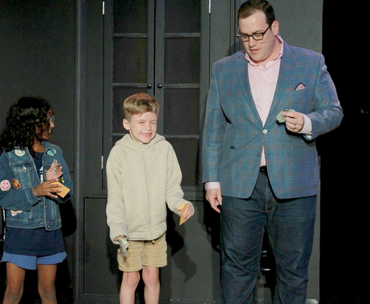 Two kid volunteers on stage with Scott Green at iO Theater