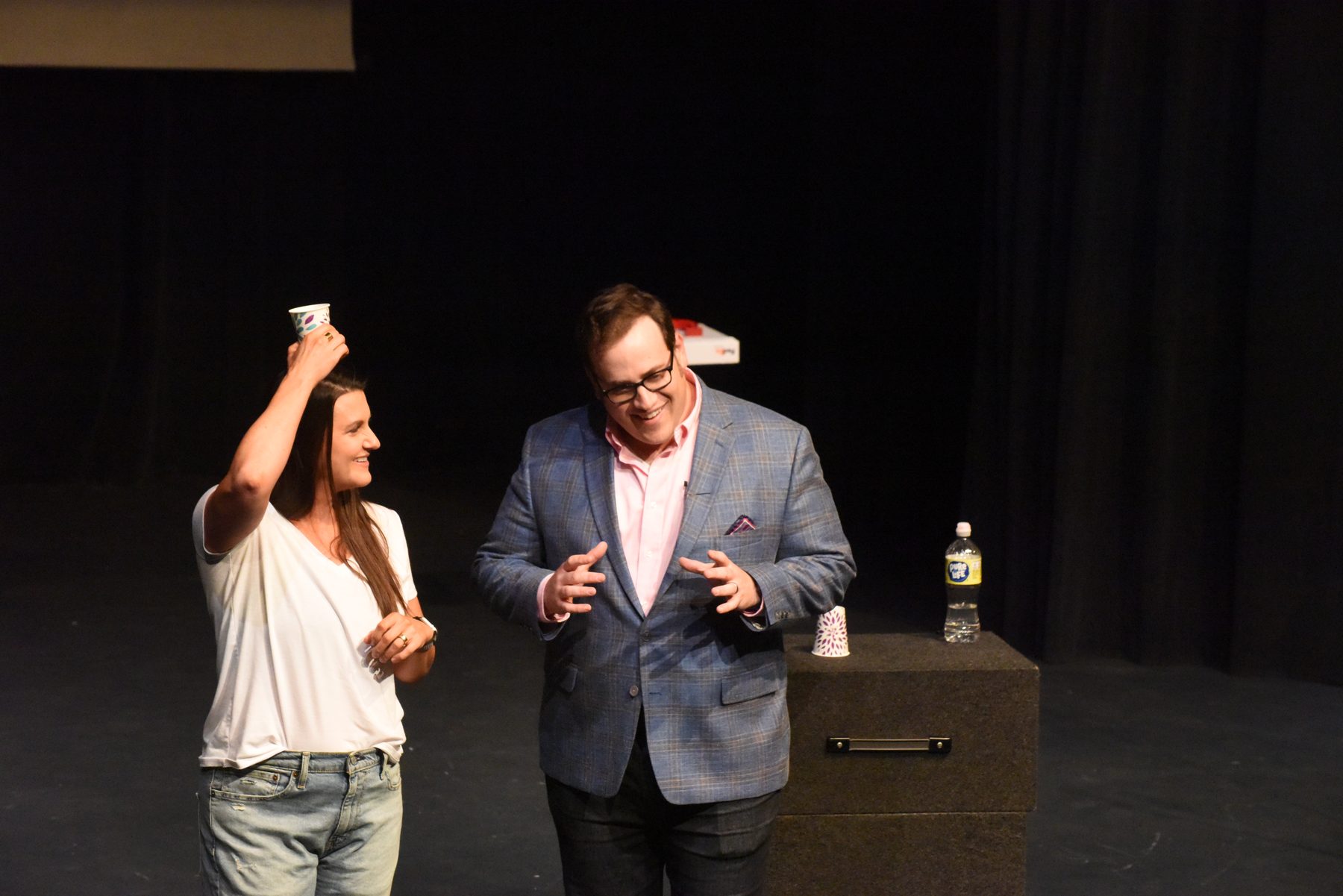 An adult volunteer on stage with Scott Green during a show